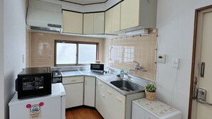Cocina compacta con microondas, tostadora y lavamanos.