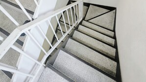 Una escalera con barandillas blancas y una lámpara en la pared.