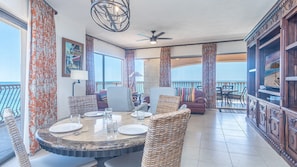 Enjoy a meal at the large dining table surrounded by comfortable chairs, or relax on the sofa near the window with a view of the ocean.