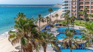 Un resort con varias piscinas, una playa y vista al océano.