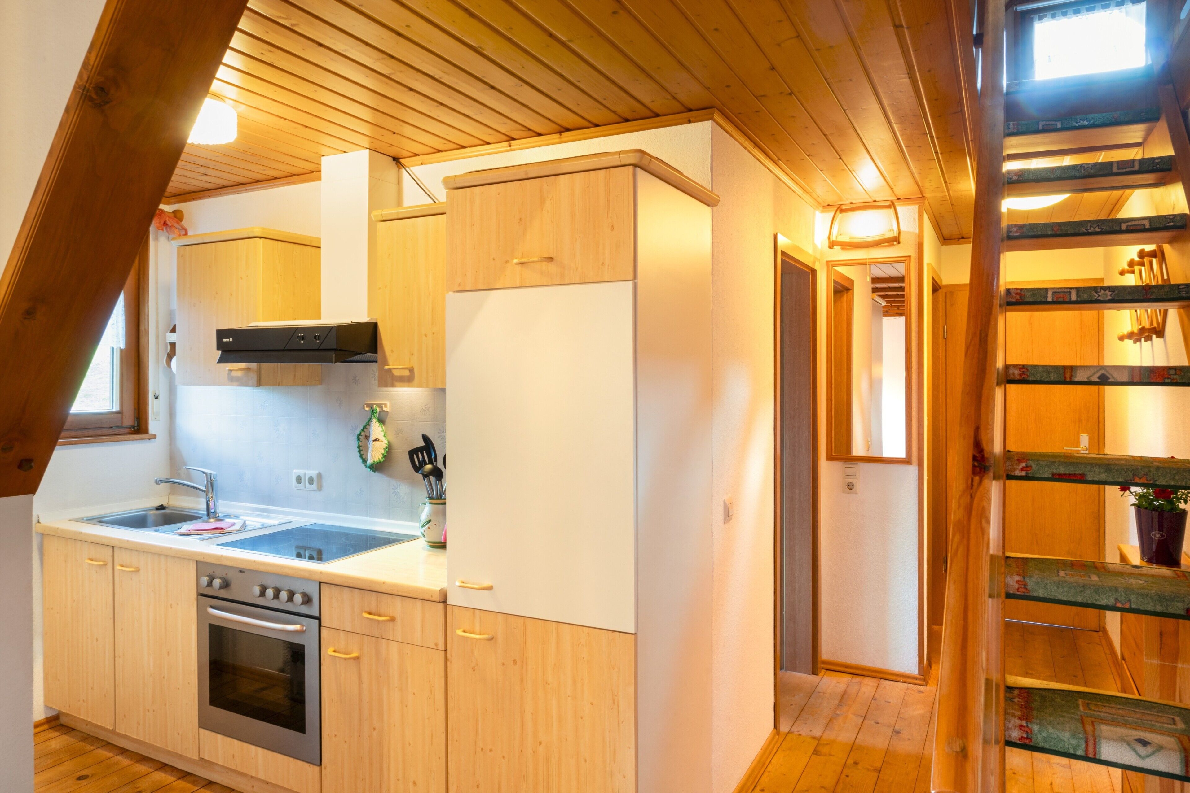 A kitchen with wooden cabinets, a stainless steel oven, and a window.