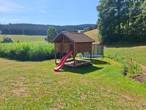 A playground with a slide and trampoline.