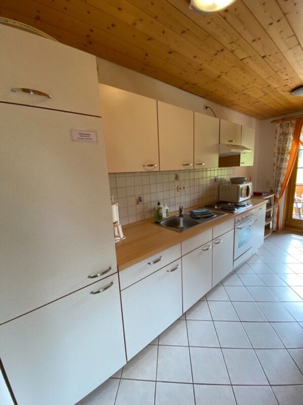 A kitchen with white cabinets, a microwave, and a sink.