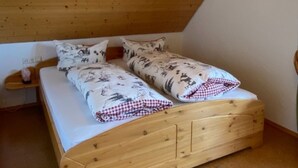 A wooden bunk bed with a checkered blanket and a framed picture on the wall. - Holiday Apartment 'Untertalblick' with Shared Garden and Balcony, Farm Stay (Eisenbach)