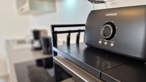 Una cocina con campana de acero inoxidable, microondas y cafetera.