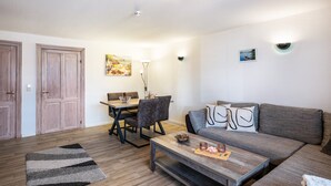Una sala de estar con sofá, mesa de centro y comedor con sillas y una mesa.
