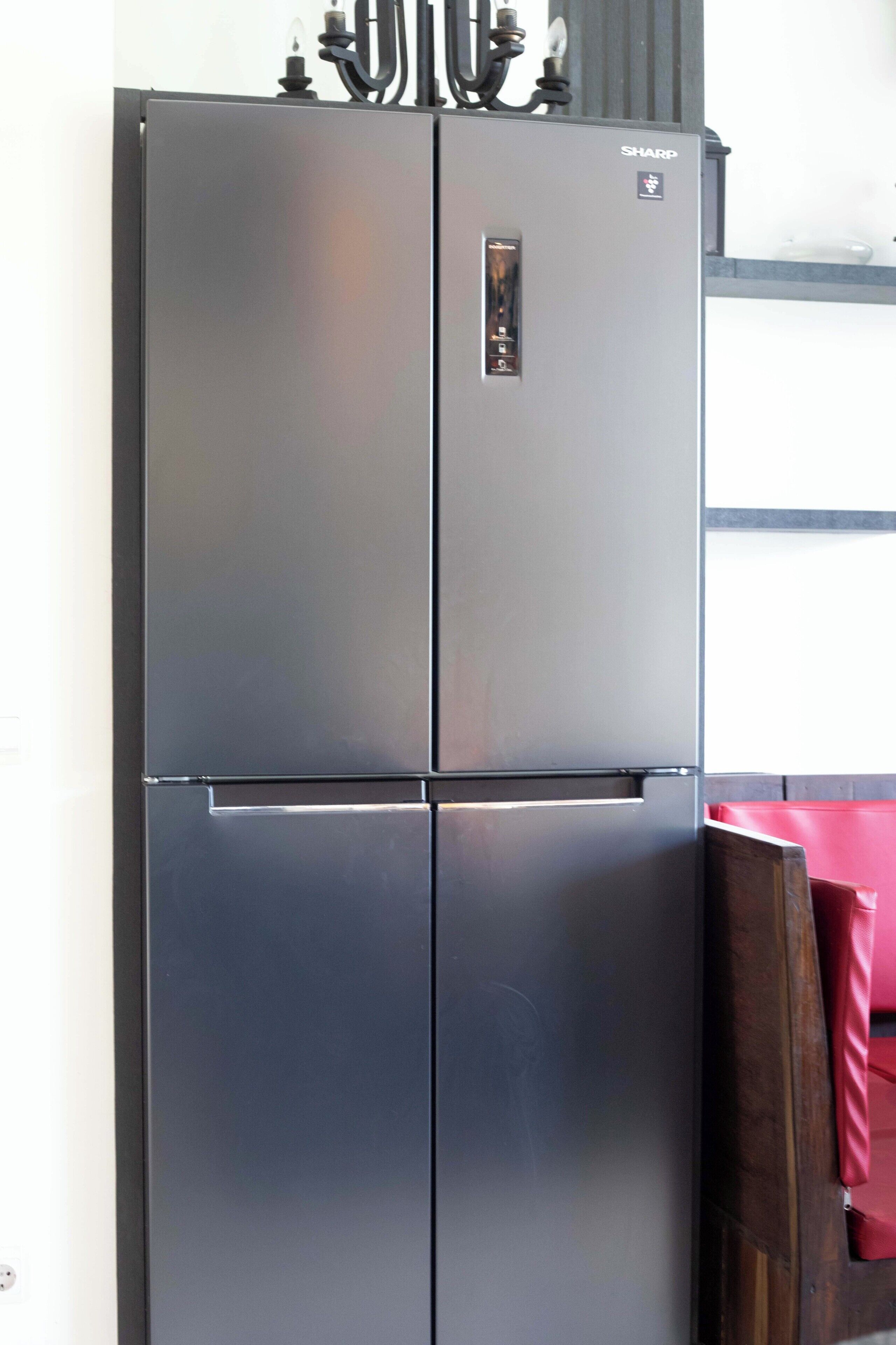 Ein Edelstahl-Kühlschrank mit Bedienfeld und einem separaten Gefrierfach.