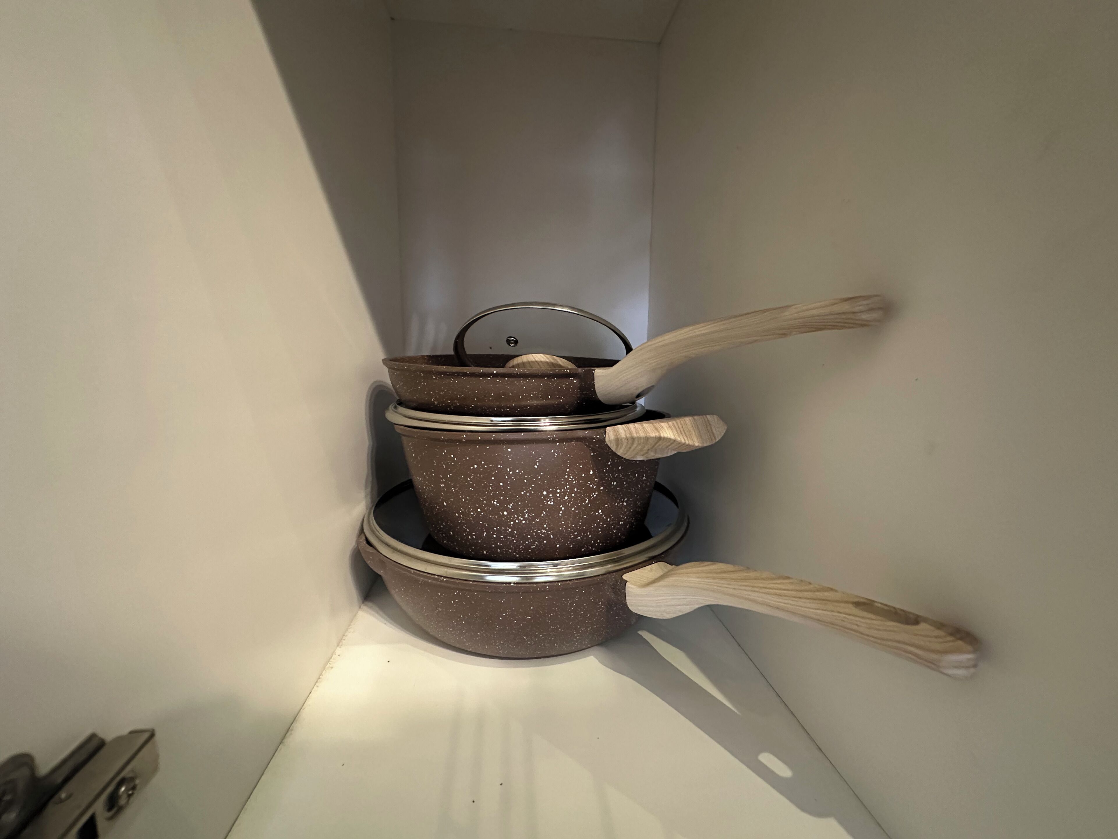 Un angolo cottura con pentole impilate e utensili di legno.