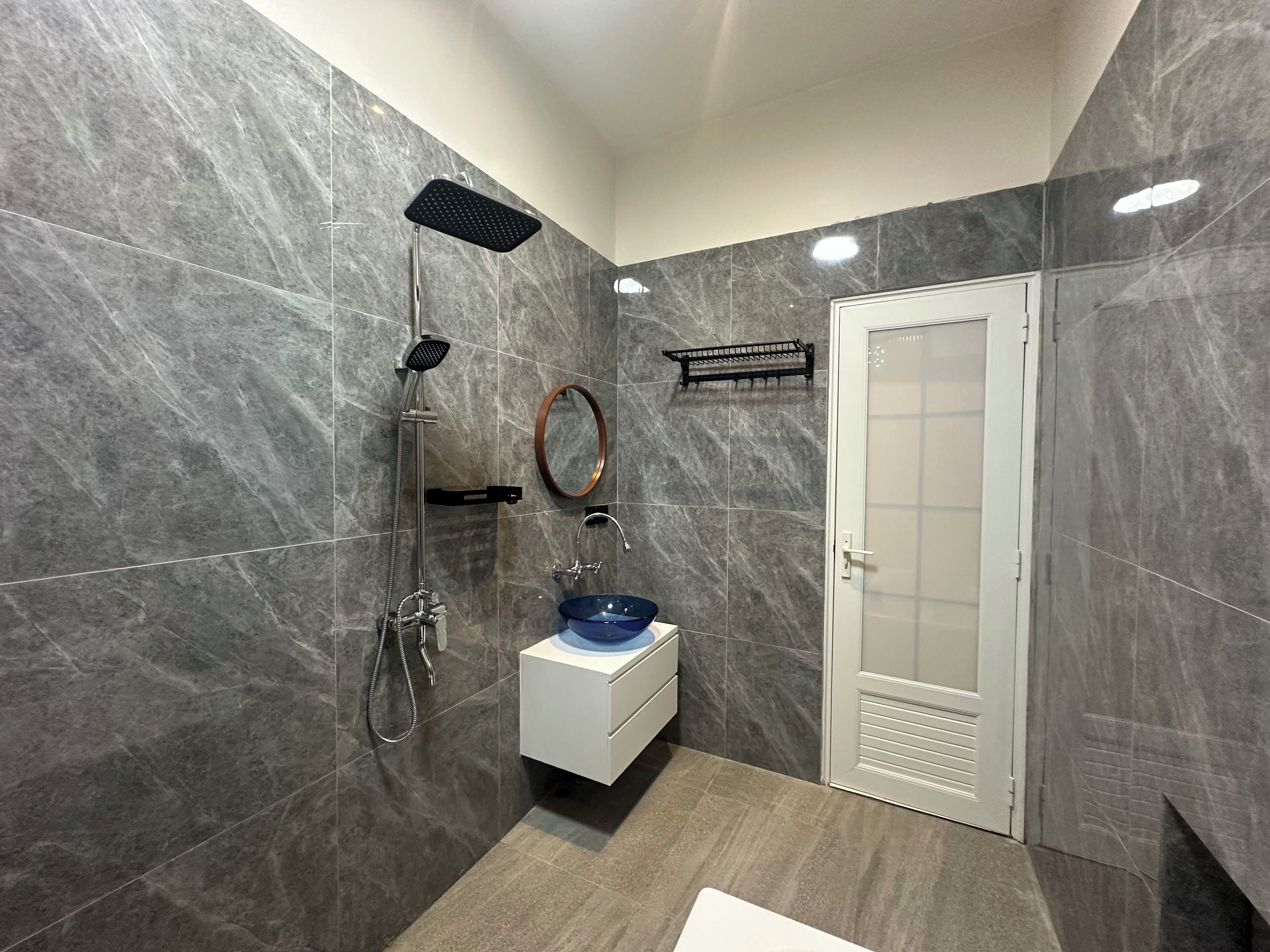 Een moderne badkamer met een douche, wastafel en toilet.
