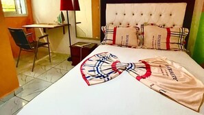 A hotel room with a bed, a desk, a chair, a mirror, and a window. - 1 Bed Studio Sleeps 2 - Canal View, Parking, Wifi (Douala)