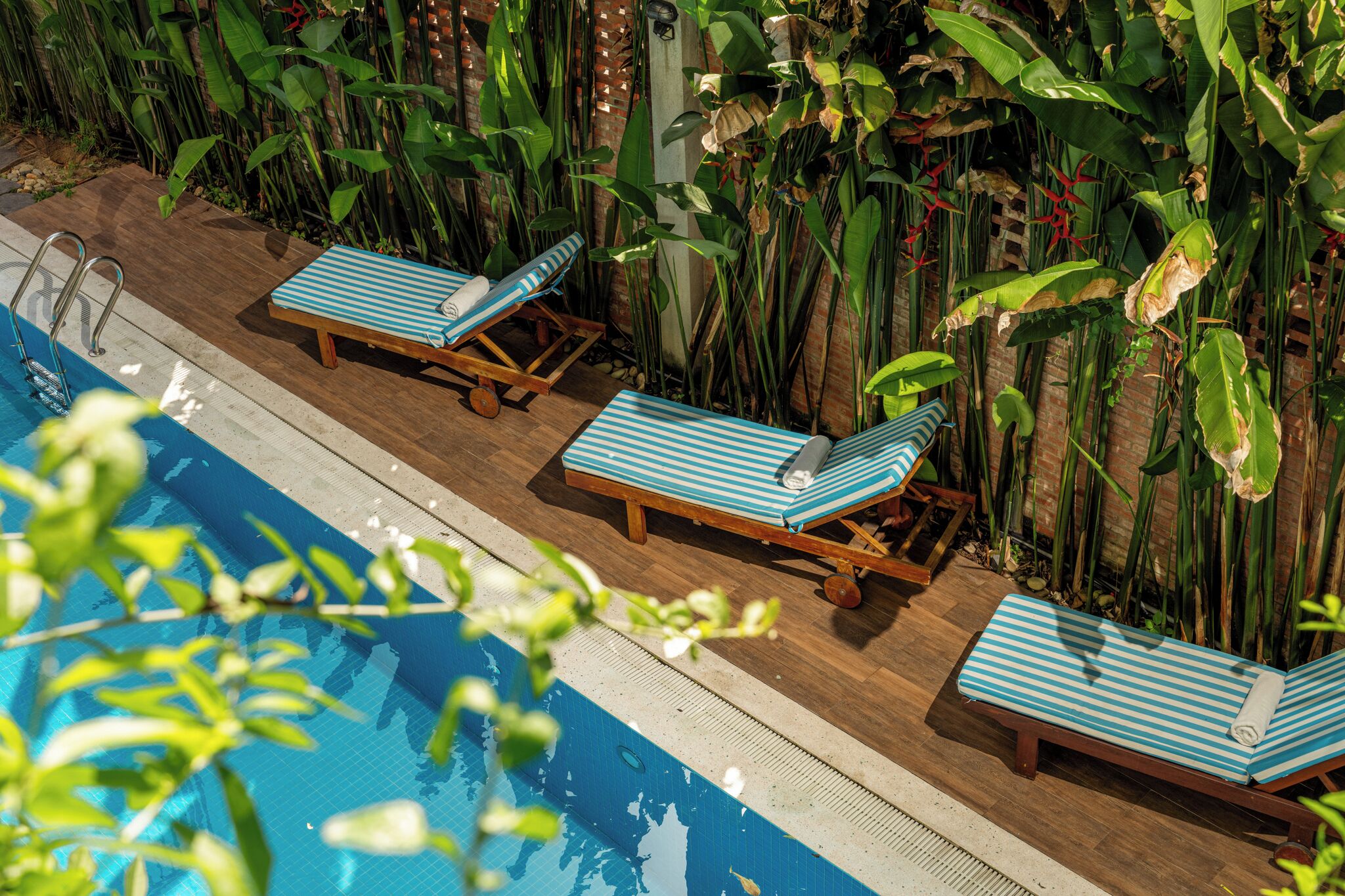 A poolside area with lounge chairs and a pool.