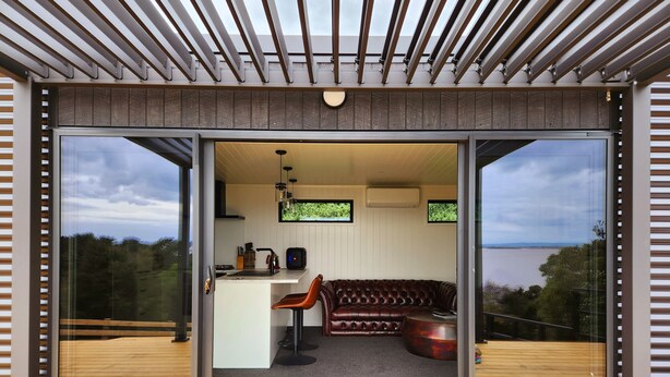 Un interior moderno con cocina, zona de estar y ventanas amplias que ofrecen vistas al exterior.