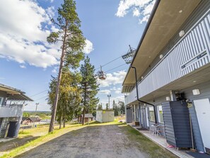Un edificio con una zona exterior cubierta, un sistema de teleférico y cielo despejado.
