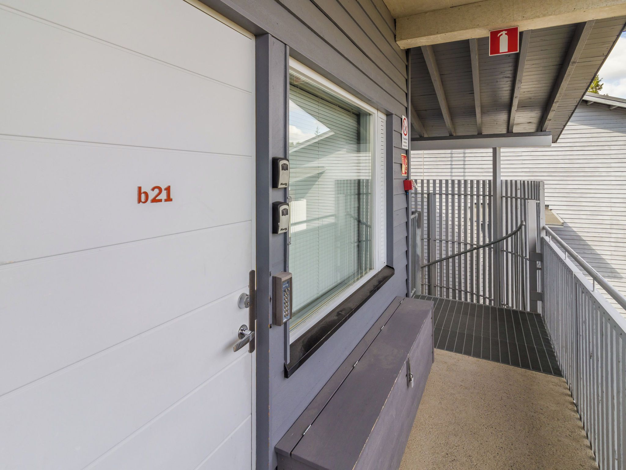 A hotel entrance with a door labeled 'b21,' a window, and a fire exit sign.