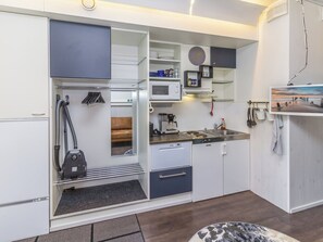Une cuisine compacte équipée d’un four à micro-ondes, d’une machine à café et d’un évier.