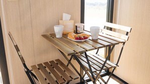 Una mesa de madera con fresas y croissants, un recipiente para café y una caja de pañuelos.