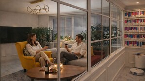 Un salon moderne avec un canapé, une table basse et une bibliothèque remplie de livres.
