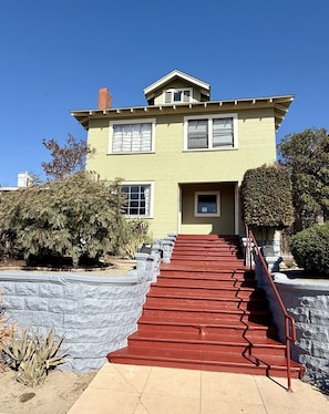A two-story house with a red staircase leading to the front door. - 3-Bedroom, Private Backyard, Historic, Prime Location (San Diego)