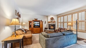 A cozy living room with a fireplace, a television, and a comfortable seating area. - Mountain Escape | Hot Tub + Walk to Town (Breckenridge)