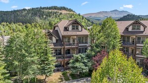 A multi-story hotel with a traditional architectural style, featuring a balcony on the second floor and a view of a mountainous landscape. - Mountain Escape | Hot Tub + Walk to Town (Breckenridge)