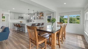 A spacious kitchen with a central island, wooden chairs, and a dining table. - Historic Farmhouse with Pool & Hot Tub in Wine Country, Near Washington, DC (Hamilton)