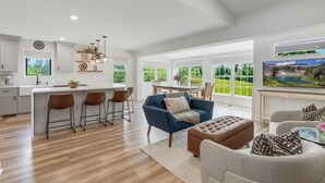 A spacious kitchen with a large island, bar stools, and a dining area with a view of the outdoors. - Historic Farmhouse with Pool & Hot Tub in Wine Country, Near Washington, DC (Hamilton)