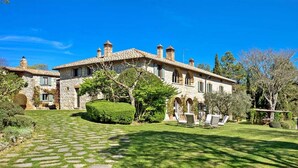 A stone villa with a paved driveway, a well-maintained lawn, and outdoor seating. - Luxurious independent villa with 12 beds in Val d'Orcia (Sarteano)