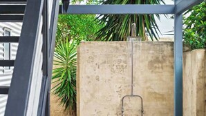 A concrete wall with a metal pipe structure, surrounded by greenery. - Surfers Paradise—Oceanview Garden Beach House (Yallingup)