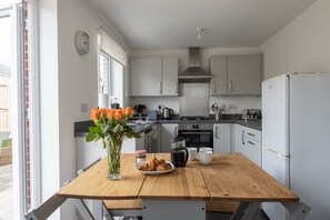 Enjoy a warm breakfast at the kitchen table, complete with an oven and stainless steel range hood.