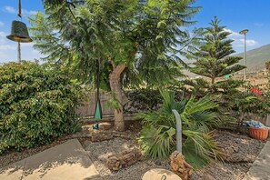 A garden with a variety of plants, a tree, and a hanging bell. - Vacation Home 'Villa En Taro' with Sea View, Private Terrace and Wi-Fi (Güímar)