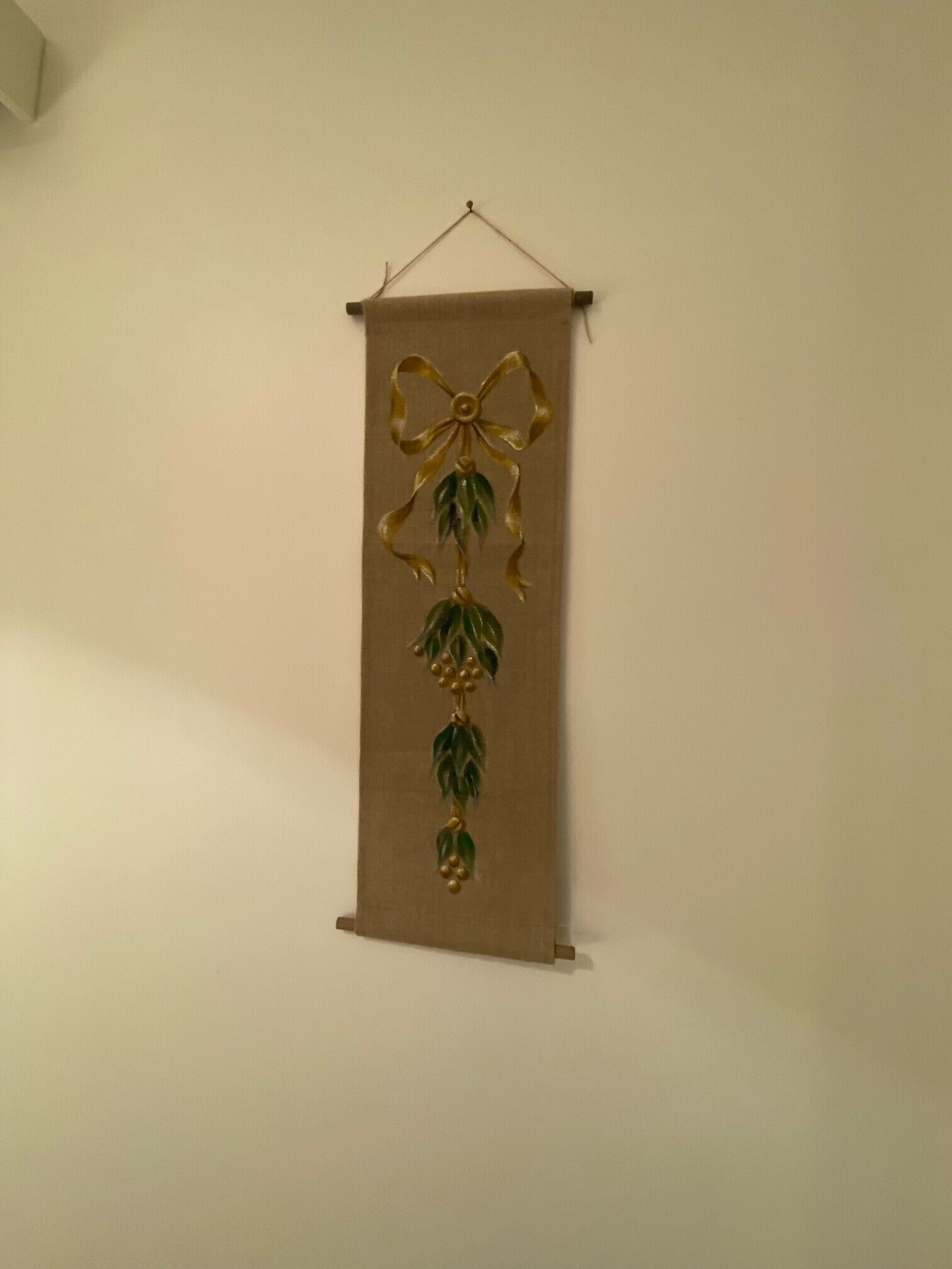 A wall-mounted decorative item with a bow and hanging elements.