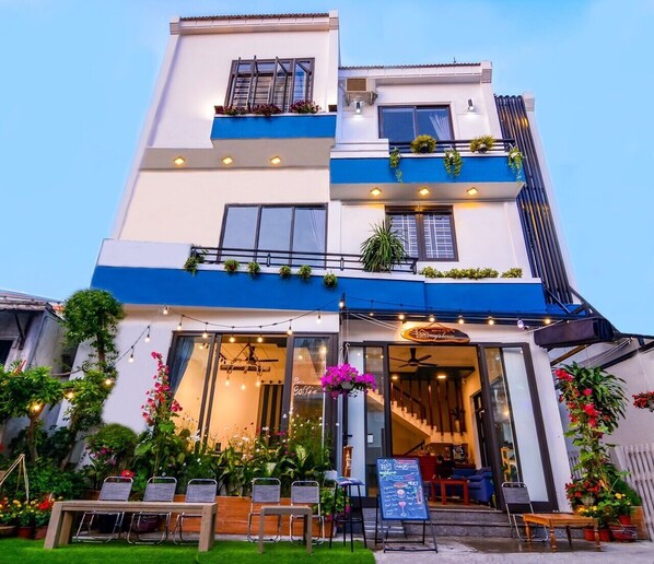 A two-story building with a cafe on the ground floor, featuring outdoor seating and a menu board. - May's House Hoi An Ancient Town Center (Da Nang)