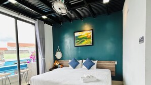 A bedroom with a bed, a view of a pool, and a ceiling fan. - May's House Hoi An Ancient Town Center (Da Nang)