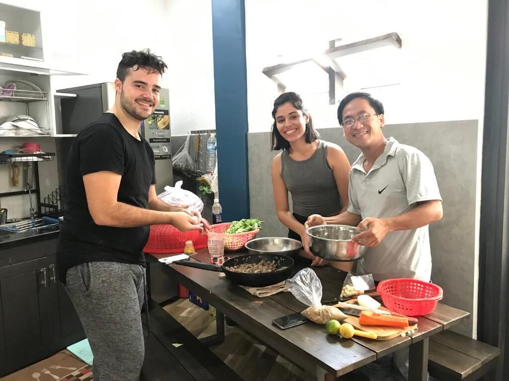 Une cuisine avec un plan de travail en acier inoxydable, un panier rouge et une poêle en métal.