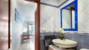A bathroom with a sink, mirror, and towel rack.