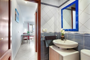 A bathroom with a sink, mirror, and towel rack. - Holiday Apartment 'Casa Dajate, El Cotillo' with Sea Views, Shared Terrace and Wi-Fi (El Cotillo)
