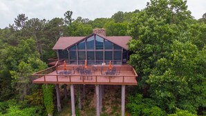 A wooden deck with outdoor seating and a glass-enclosed structure.