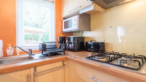 Una cocina compacta equipada con microondas, tostadora y estufa a gas.