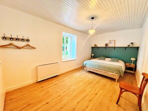 A bedroom with a bed, a chair, a radiator, a window, and a wall-mounted light fixture. - Holiday Home 'Maison Proche Sables D'Olonne 8p' with Private Terrace and Air Conditioning (Sainte-Foy)
