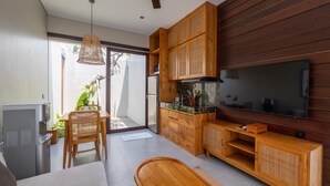 Une cuisine moderne avec des meubles en bois, un aquarium intégré et un grand téléviseur.