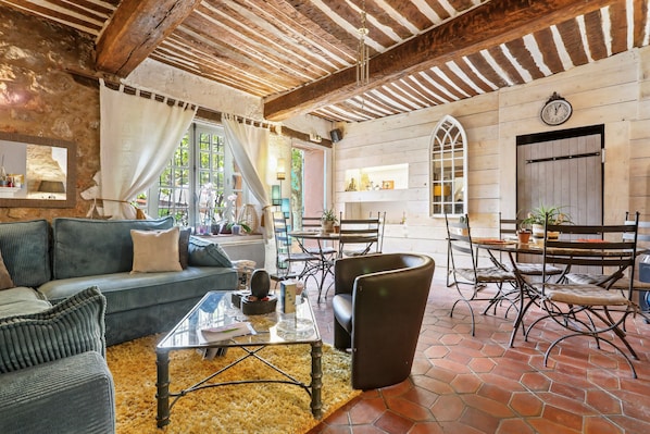A rustic interior with a sofa, coffee table, and dining area with chairs and a table.