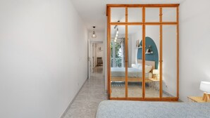 A bedroom with a bed, a wooden wardrobe, a desk, and a chair. - Apartment 'La Fuente' with Balcony and Wi-Fi (El Paso)
