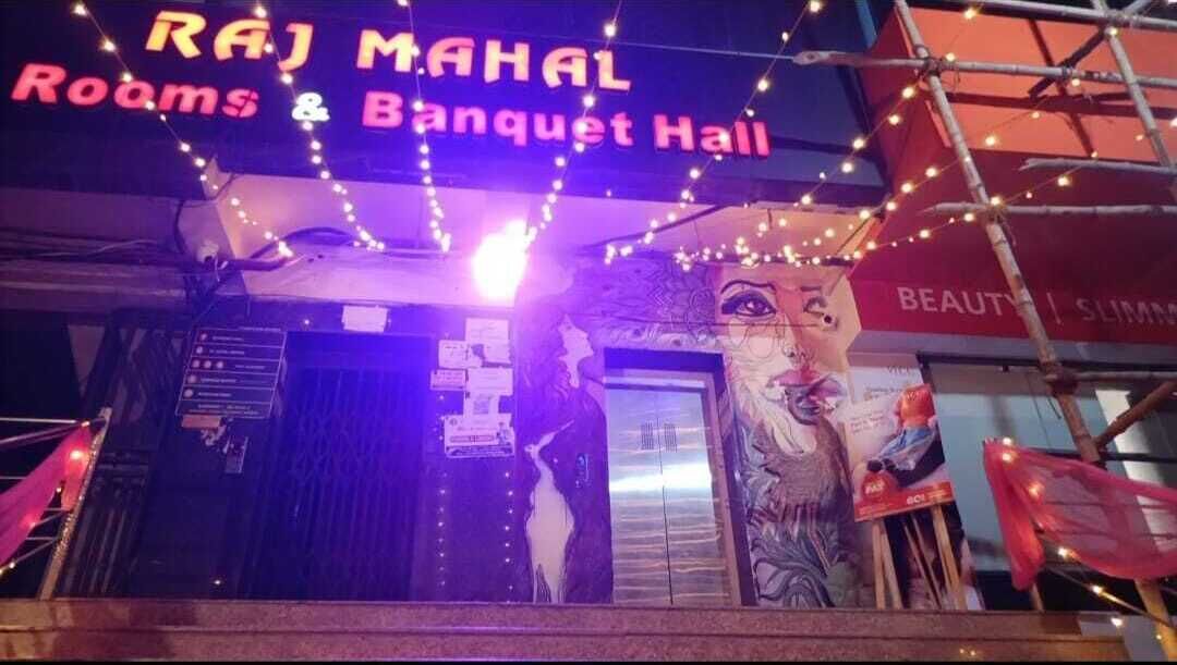 A building with a sign reading "Raj Mahal Rooms & Banquet Hall".