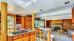 Ein Holzblockhaus-Innenraum mit Küche, Essbereich und Kamin.