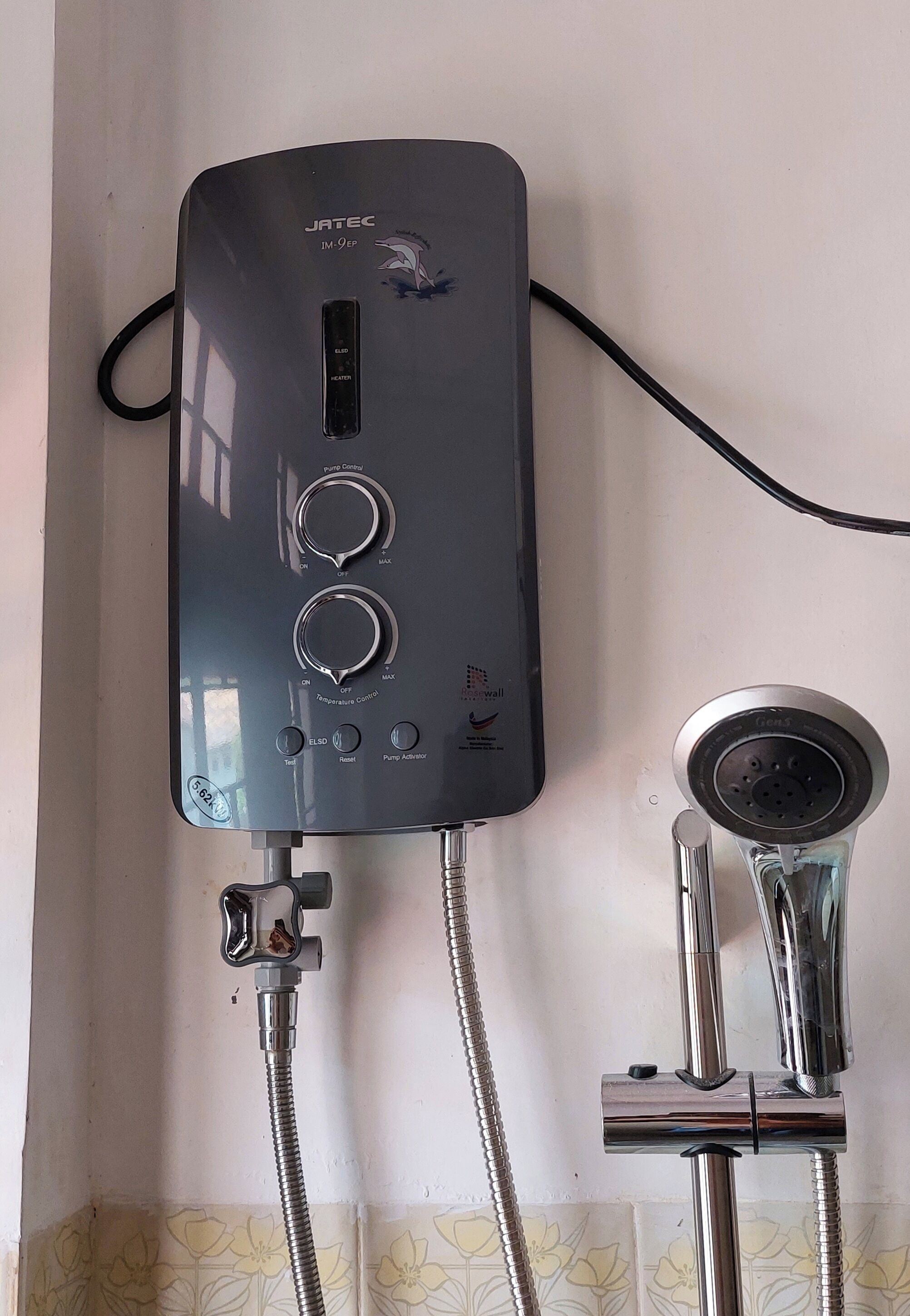 A JATEC JM-9ER water heater with control knobs, a digital display, and a power cord.