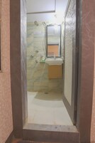 A bathroom with a shower, a sink, and a mirror.