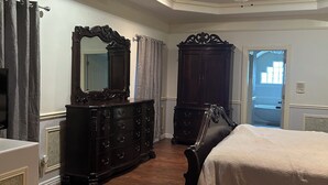 A bedroom with a large bed, a dresser, a mirror, and a ceiling fan. - Upstairs bar, palapa, 5 bedroom, king suite, Gig WiFi, great location  (Eagle Pass)