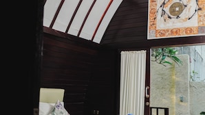 A room with a bed, a window, and a view of a garden. - Bellewood Villa (Gili Trawangan)