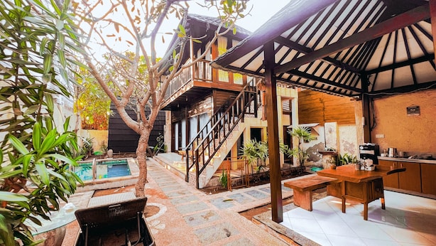 A courtyard with a pool, outdoor seating, and a staircase leading to an upper level. - Bellewood Villa (Gili Trawangan)