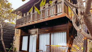 A two-story building with a balcony, a swimming pool, and a staircase leading to the upper floor. - Bellewood Villa (Gili Trawangan)